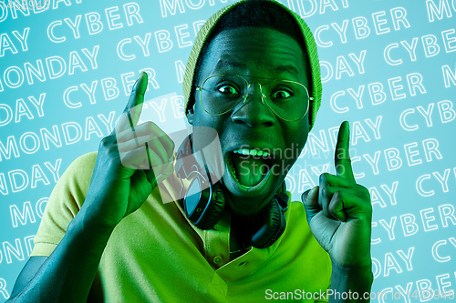 Image of Portrait of young man on blue background, black friday