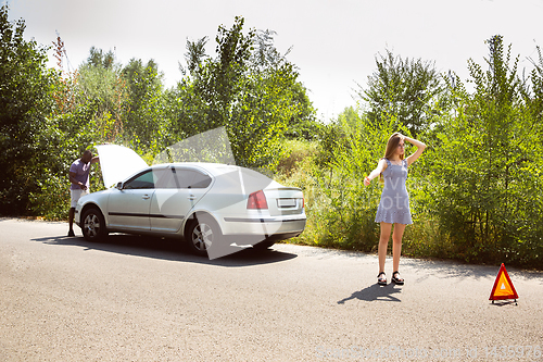 Image of Young multiethnic international couple traveling on the car in sunny day