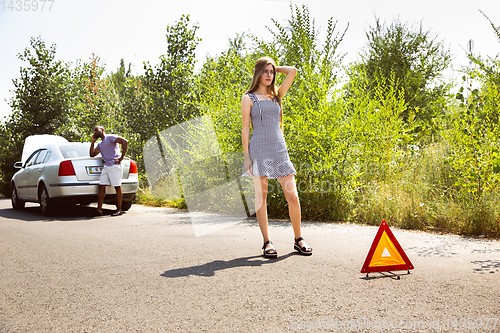 Image of Young multiethnic international couple traveling on the car in sunny day