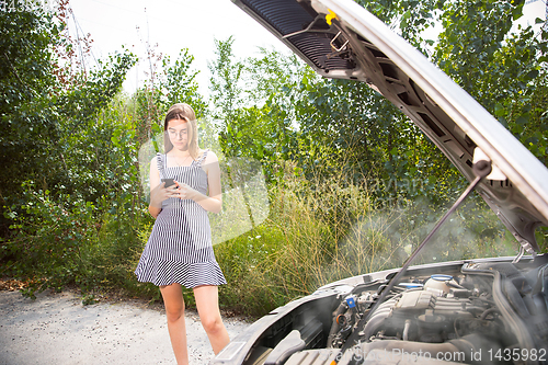 Image of Young woman traveling on the car in sunny day