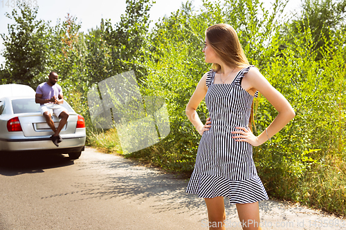 Image of Young multiethnic international couple traveling on the car in sunny day