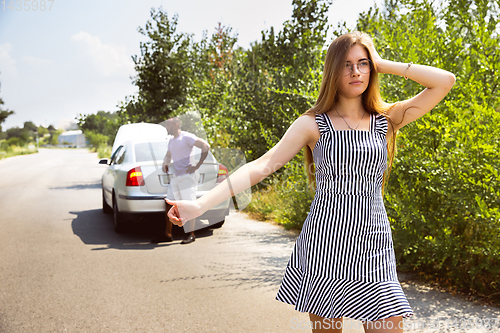 Image of Young multiethnic international couple traveling on the car in sunny day