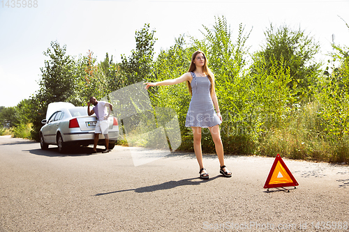 Image of Young multiethnic international couple traveling on the car in sunny day