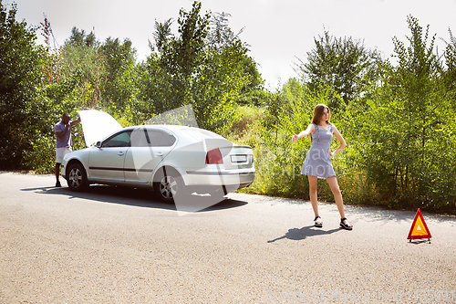 Image of Young multiethnic international couple traveling on the car in sunny day