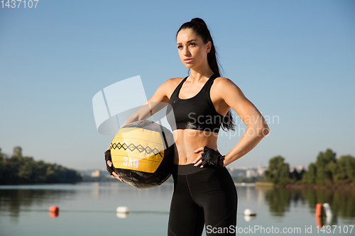 Image of Young healthy female athlete doing workout at the beach