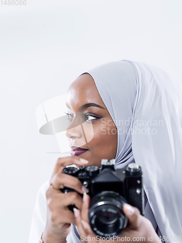 Image of african modern muslim woman using retro camera