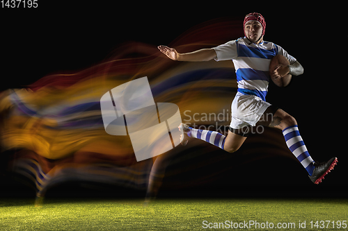 Image of One caucasian man playing rugby on the stadium in mixed light