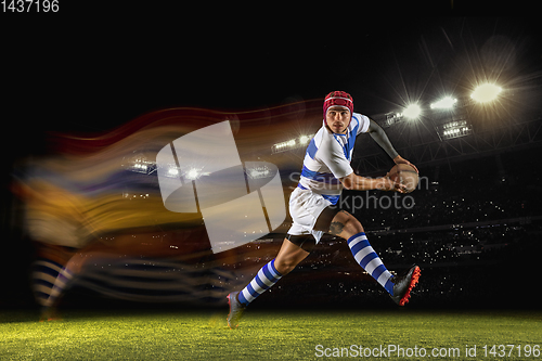 Image of One caucasian man playing rugby on the stadium in mixed light