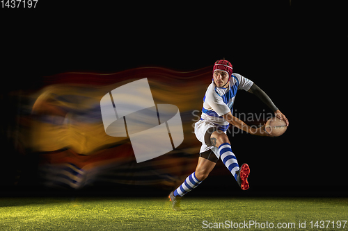 Image of One caucasian man playing rugby on the stadium in mixed light