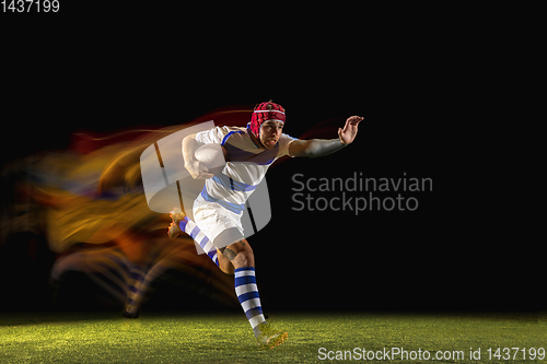 Image of One caucasian man playing rugby on the stadium in mixed light