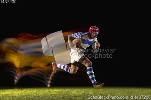 Image of One caucasian man playing rugby on the stadium in mixed light