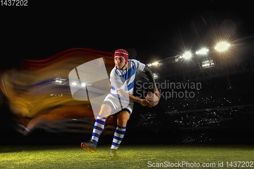 Image of One caucasian man playing rugby on the stadium in mixed light