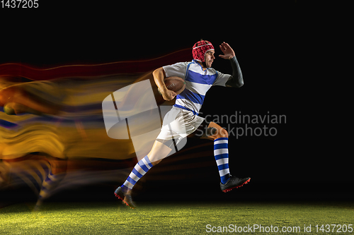 Image of One caucasian man playing rugby on the stadium in mixed light