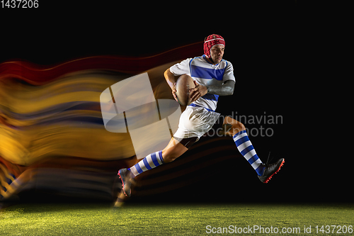 Image of One caucasian man playing rugby on the stadium in mixed light