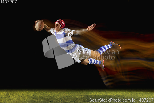 Image of One caucasian man playing rugby on the stadium in mixed light