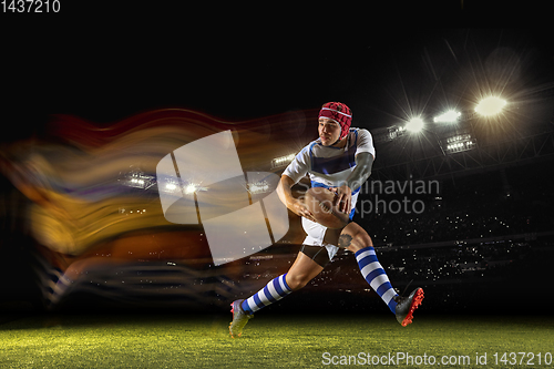 Image of One caucasian man playing rugby on the stadium in mixed light