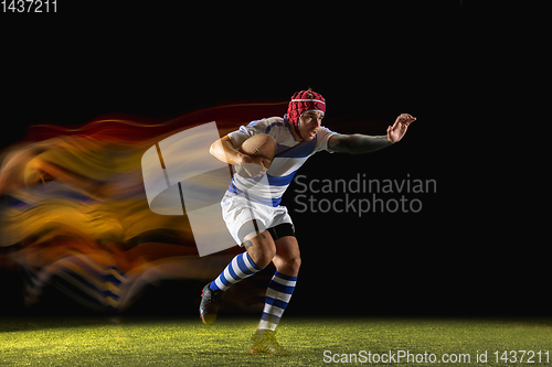 Image of One caucasian man playing rugby on the stadium in mixed light