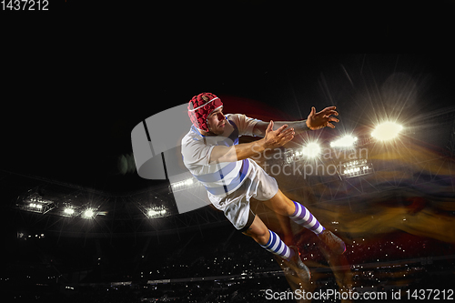 Image of One caucasian man playing rugby on the stadium in mixed light