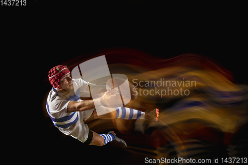 Image of One caucasian man playing rugby on the stadium in mixed light