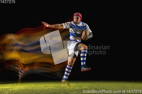 Image of One caucasian man playing rugby on the stadium in mixed light