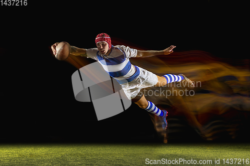 Image of One caucasian man playing rugby on the stadium in mixed light
