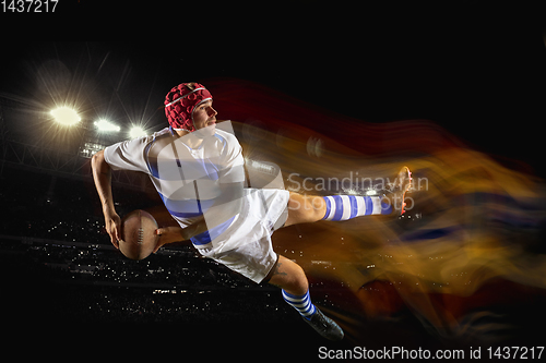 Image of One caucasian man playing rugby on the stadium in mixed light