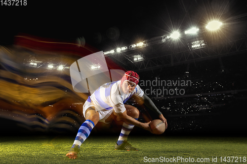 Image of One caucasian man playing rugby on the stadium in mixed light