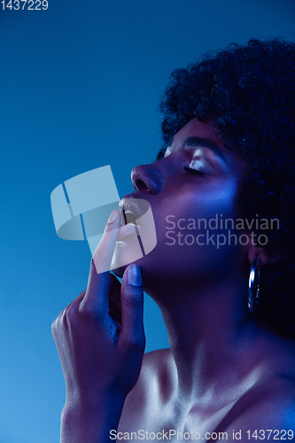 Image of Portrait of female high fashion model in neon light