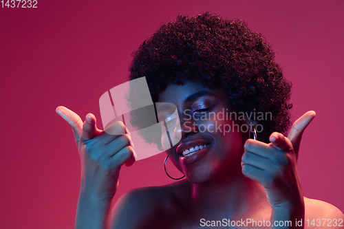 Image of Portrait of female high fashion model in neon light