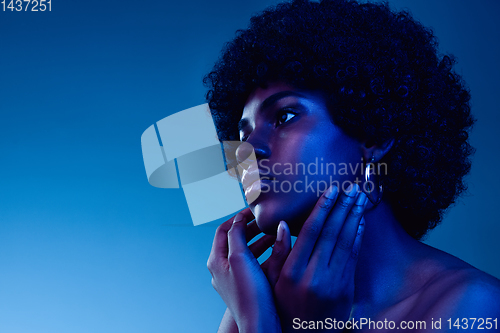 Image of Portrait of female high fashion model in neon light