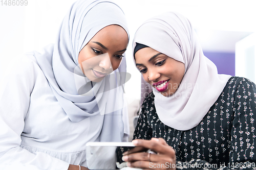 Image of african  women using smartphone at home