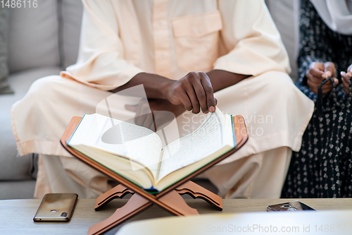 Image of african couple at home reading quran