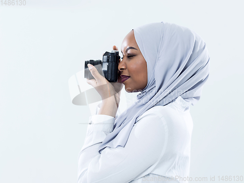 Image of african modern muslim woman using retro camera