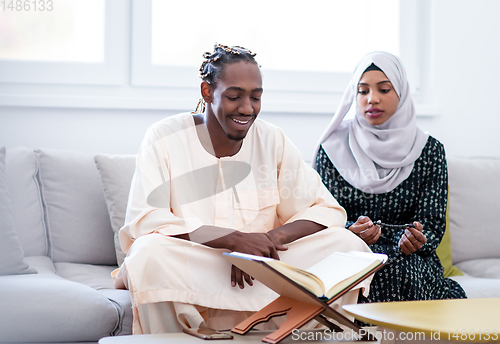 Image of african couple at home reading quran