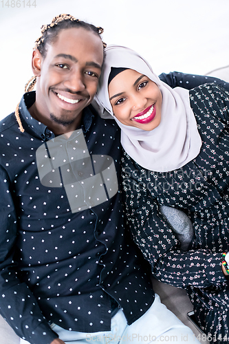 Image of African Couple Sitting On Sofa Watching TV Together