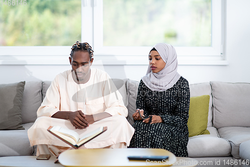 Image of african couple at home reading quran