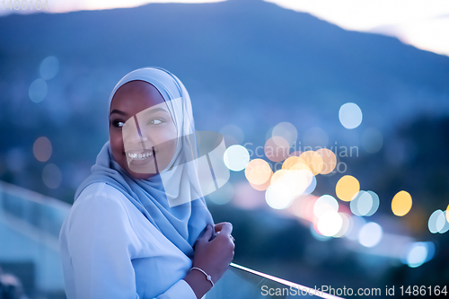 Image of African  modern Muslim woman in night at balcony