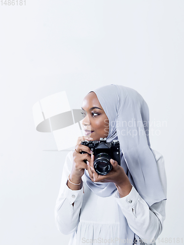 Image of african modern muslim woman using retro camera