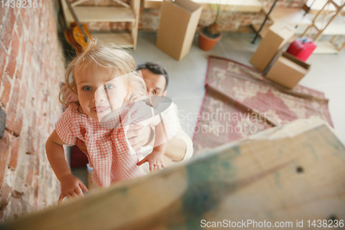 Image of Young father and his daughter moved to a new house or apartment
