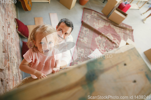 Image of Young father and his daughter moved to a new house or apartment