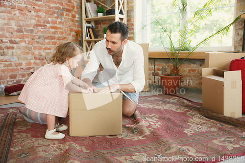 Image of Young father and his daughter moved to a new house or apartment