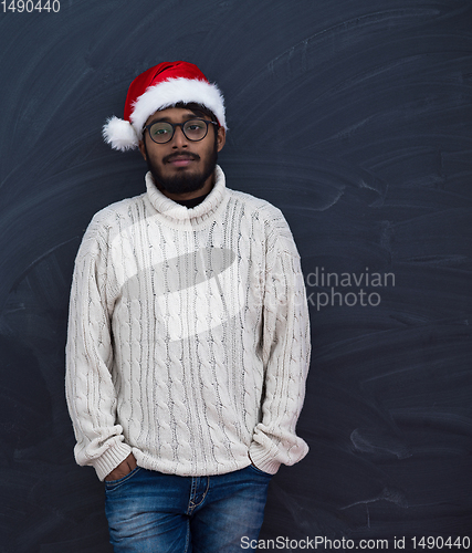 Image of Indian man wearing traditional Santa  hat  and white sweater