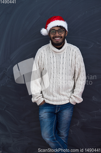 Image of Indian man wearing traditional Santa  hat  and white sweater