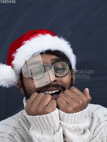 Image of Indian man wearing traditional Santa  hat  and white sweater