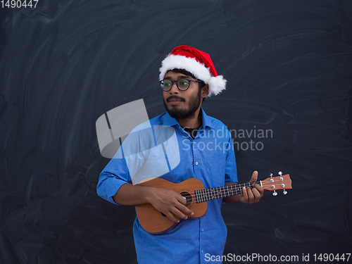Image of Santa playing Latin America traditional small guitar