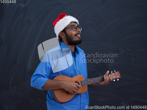 Image of Santa playing Latin America traditional small guitar