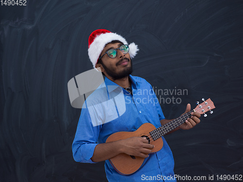 Image of Santa playing Latin America traditional small guitar