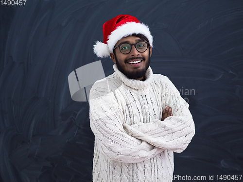 Image of Indian man wearing traditional Santa  hat  and white sweater