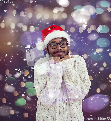 Image of Indian man wearing traditional Santa  hat  and white sweater