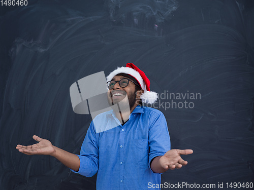 Image of Indian man wearing traditional Santa Claus hat